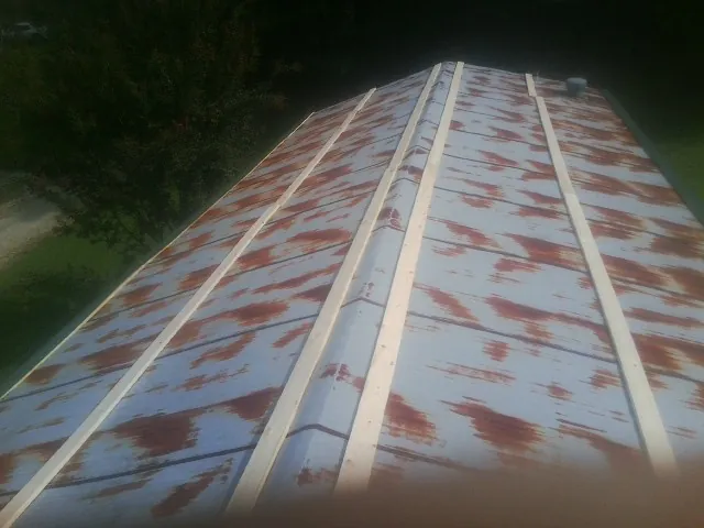 Rusted metal roof panels with new wood purlins before replacement — Storm Damage Roof Repair in Stitzer by Roofing Brothers